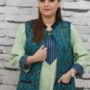 Woman wearing a sleeveless teal jacket with embroidered leaf motifs, crepe lining, and front pockets, styled over a light green kurta.
